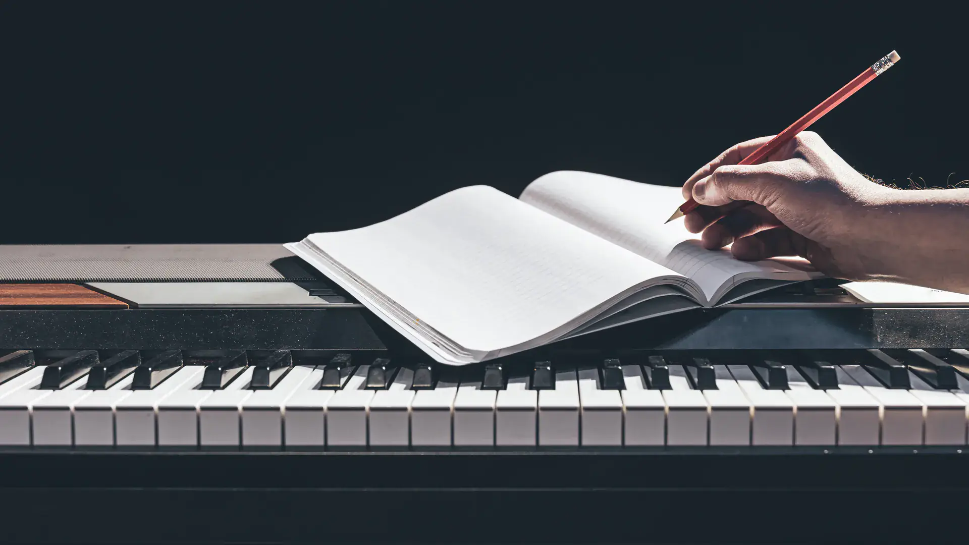 Hand writing music notes in a notebook — ABRSM theory and exam centre at Concerto Music Place